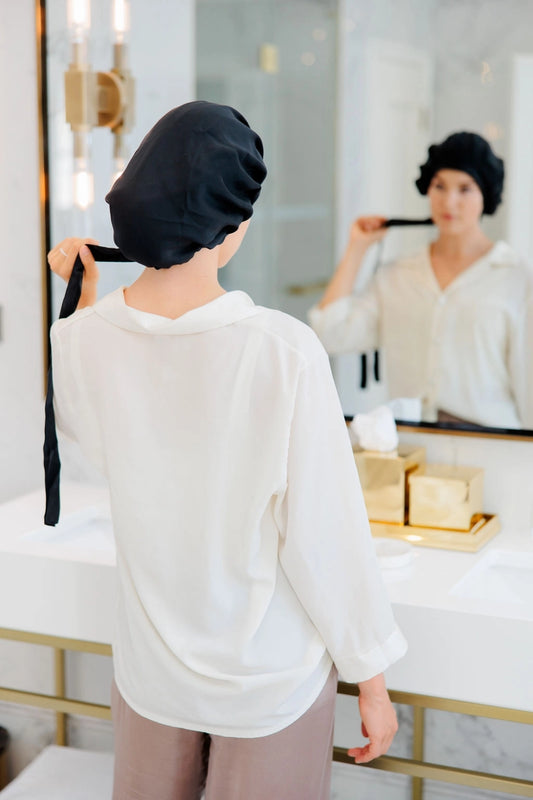 Nainen, jolla on päässään silkkinen yömyssy hiuksille - pitkät hiukset - hiustenhoito